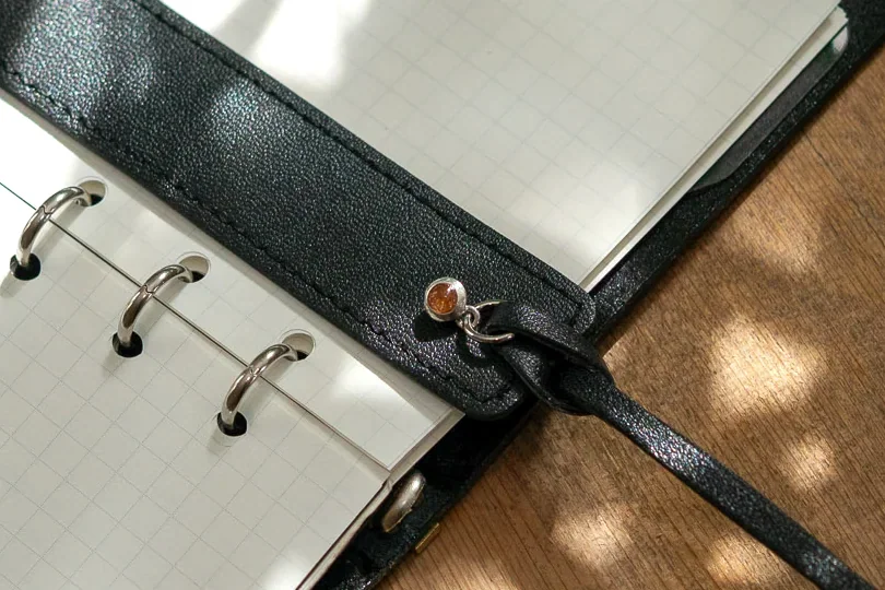 革の手帳のひもに取り付けたmofulのチャーム